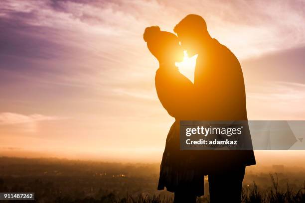 diverse couple engagement silhouettes at sunset - secret love stock pictures, royalty-free photos & images