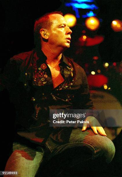 Photo of SIMPLE MINDS; Simple Minds, Nederland, Paradiso, A'dam, , Pop, wave, zanger Jim Kerr zit op het podium met zijn hand rustend op zijn knie en...