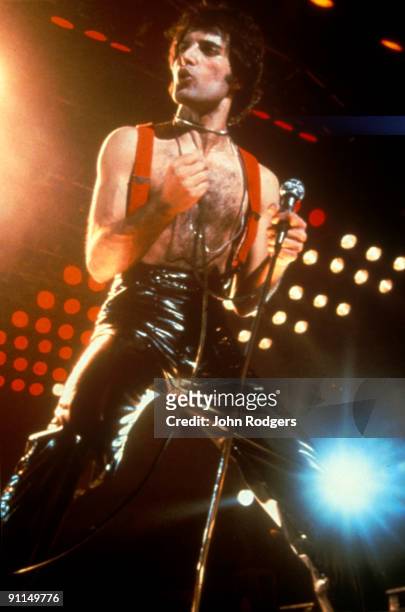 Photo of Freddie MERCURY and QUEEN; Freddie Mercury performing live on stage, leather trousers, braces, barechested