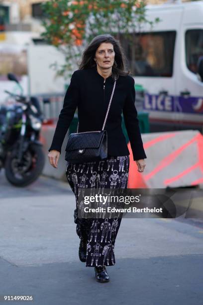 Guest wears a black jacket, a Chanel bag, a skirt, shoes, outside Chanel, during Paris Fashion Week -Haute Couture Spring/Summer 2018, on January 23,...