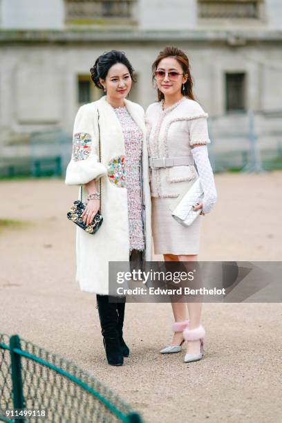 Guests wear white Chanel outfits and bags outside Chanel, during Paris Fashion Week -Haute Couture Spring/Summer 2018, on January 23, 2018 in Paris,...