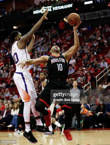 Eric Gordon of the Houston Rockets drives around Troy Daniels of the Phoenix Suns in the second half at Toyota Center on January 28, 2018 in Houston,...