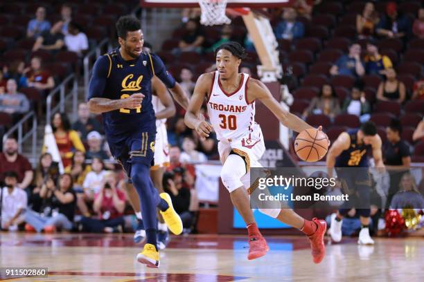 Elijah Stewart of the USC Trojans handles the ball against Marcus Lee of the California Golden Bears during a PAC12 college basketball game at Galen...