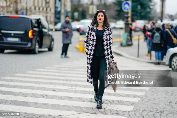 Guest wears a black and white coat, outside Chanel, during Paris Fashion Week -Haute Couture Spring/Summer 2018, on January 23, 2018 in Paris, France.