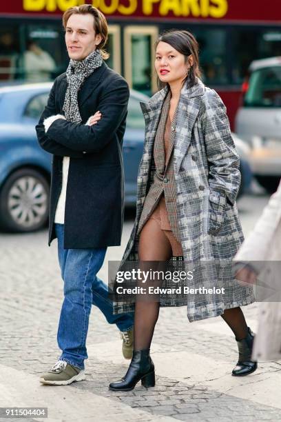 Guest wears a gray checked pattern trench coat, tights, black shoes, outside Chanel, during Paris Fashion Week -Haute Couture Spring/Summer 2018, on...