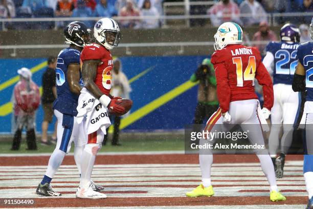 Delanie Walker of the Tennessee Titans celebrates his touchdown with Jarvis Landry of the Miami Dophins as Deion Jones of the Atlanta Falcons walks...