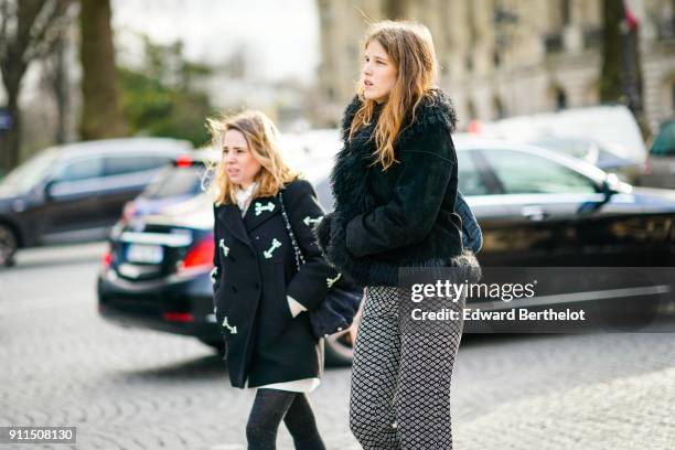 Guest wears a coat with fur, flare pants, outside Chanel, during Paris Fashion Week -Haute Couture Spring/Summer 2018, on January 23, 2018 in Paris,...