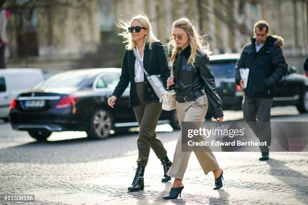 Guest wears sunglasses, a black leather jacket, beige flare pants, outside Chanel, during Paris Fashion Week -Haute Couture Spring/Summer 2018, on...