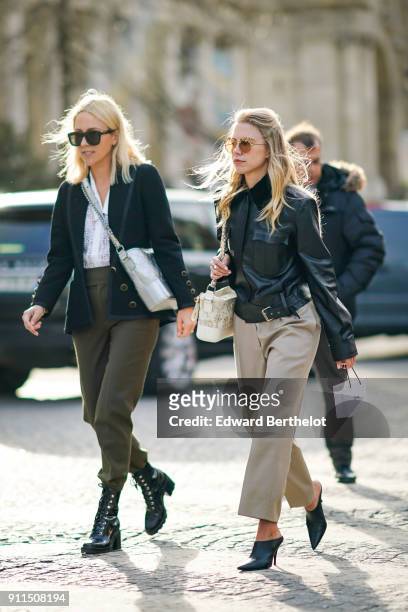 Guest wears sunglasses, a black leather jacket, beige flare pants, outside Chanel, during Paris Fashion Week -Haute Couture Spring/Summer 2018, on...