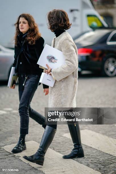 Guest wears a white coat, black leather boots, outside Chanel, during Paris Fashion Week -Haute Couture Spring/Summer 2018, on January 23, 2018 in...