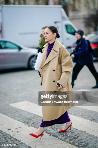 Guest wears a trench coat, red shoes, a purple dress, outside Chanel, during Paris Fashion Week -Haute Couture Spring/Summer 2018, on January 23,...
