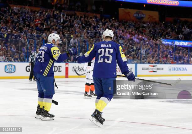 Brad Marchand of the Boston Bruins and Mike Green of the Detroit Red Wings celebrate after a goal in the first half during the 2018 Honda NHL...