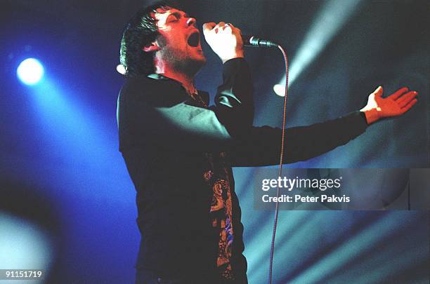 Photo of KASABIAN, Kasabian, Paradiso, Amsterdam, Nederland, , Pop, britpop, de zanger houdt tijdens het zingen met de ene, hand de microfoon vast en...