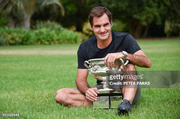 Switzerland's Roger Federer holds the Australia Open trophy at Government House as he poses for pictures following his win in the Australian Open in...