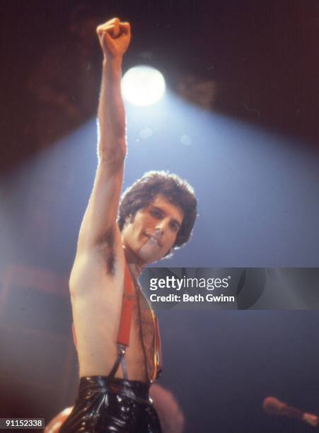 Photo of QUEEN and Freddie MERCURY, Freddie Mercury performing on stage, punching air