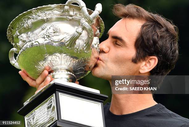 Switzerland's Roger Federer kisses the Australia Open trophy at Government House as he poses for pictures following his earlier win in the Australian...