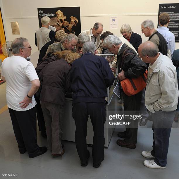 Visitors view gold artifacts at the Staffordshire Hoard exhibition at the Birmingham Museum and Art Gallery in Birmingham, central England, on...