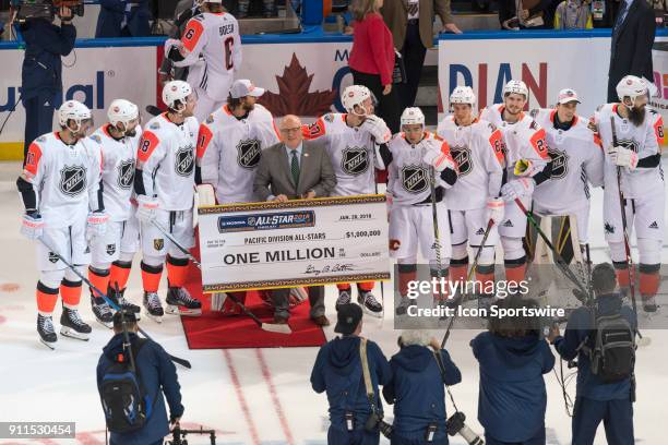 Deputy commissioner Bill Daly poses with the victorious Pacific team with a million dollar check after the championship game of the NHL All-Star Game...