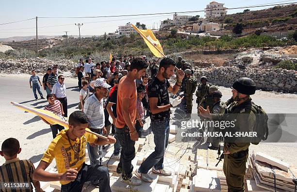 Israeli soldiers stand guard opposite Palestinian and foreign activists during a protest against Israel's controversial separation barrier in the...