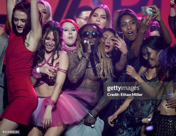 Audience members, including adult film actress Riley Reid , join rapper Lil' Wayne onstage as he performs during the 2018 Adult Video News Awards at...