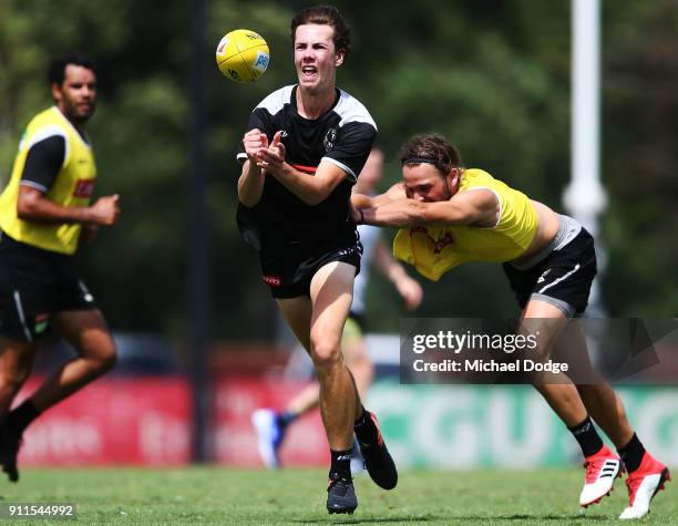 Callum Brown handballs away from Tim Broomhead during a Collingwood Magpies AFL training session on January 29, 2018 in Melbourne, Australia.