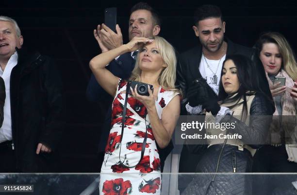 Pamela Anderson enjoys the arrivals of paratroopers on the pitch before the French Ligue 1 match between Olympique de Marseille and AS Monaco at...