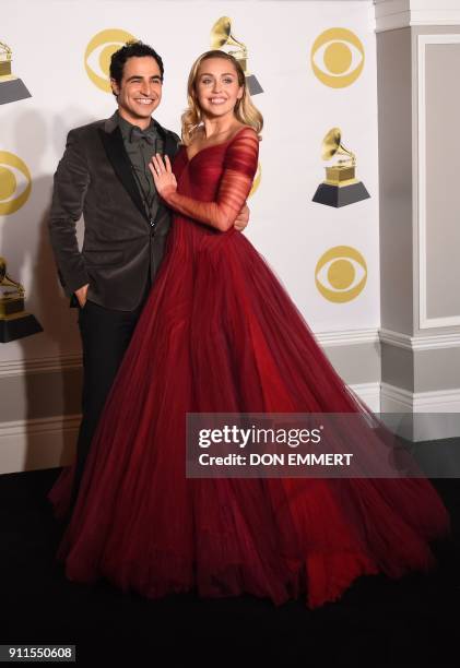 Fashion designer Zac Posen and singer Miley Cyrus pose in the press room during the 60th Annual Grammy Awards on January 28 in New York. / AFP PHOTO...