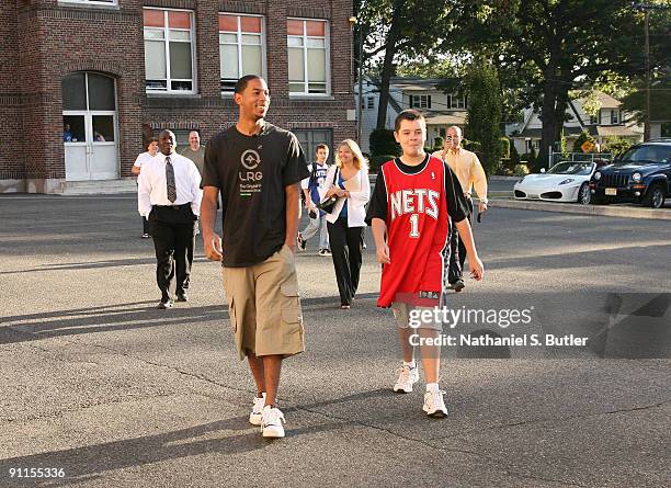 New Jersey Nets All-Star Devin Harris walks with Micheal Ulrich winner of the Nets and the American Dairy Council's Fifth Annual Take-A-NET to school...