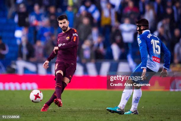 Gerard Pique of FC Barcelona plays the ball past David Lopez of RCD Espanyol during the Spanish Copa del Rey Quarter Final First Leg match between...