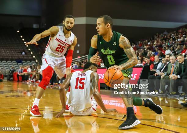 South Florida Bulls guard Stephan Jiggetts drives the ball past Houston Cougars guard Galen Robinson Jr. And Houston Cougars forward Devin Davis...