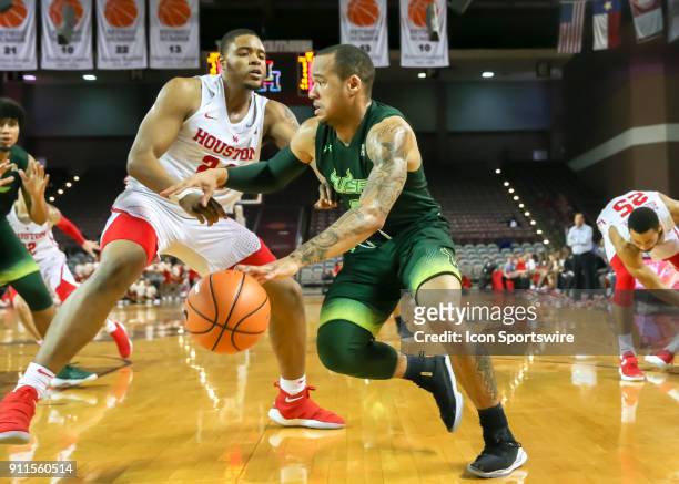 Houston Cougars forward Breaon Brady attempts to block South Florida Bulls guard Stephan Jiggetts during the college basketball game between the...