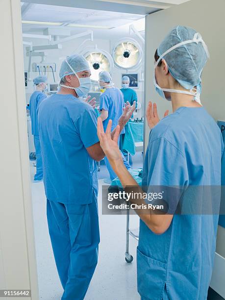 surgeons with clean hands entering operating room - surgeon walking stock pictures, royalty-free photos & images