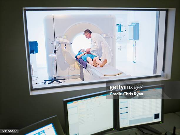 technician giving patient mri examination - mri machine stockfoto's en -beelden