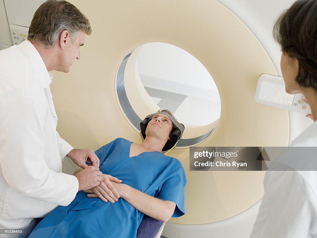 Technician preparing patient  for MRI examination