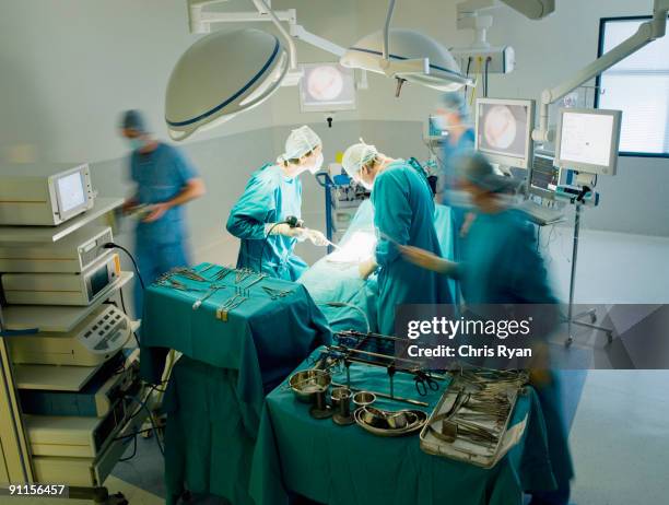 cirurgiões efectuar a operação em sala de cirurgia com assistência - sala de cirurgia com assistência imagens e fotografias de stock