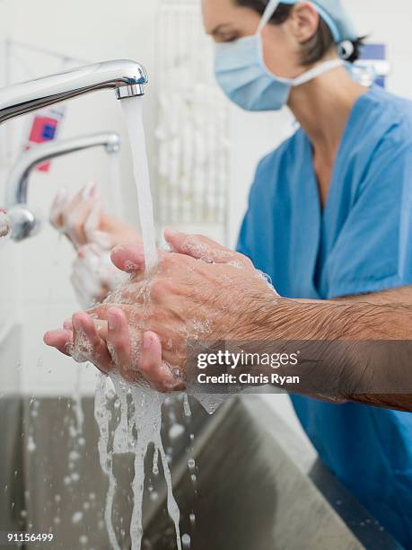 surgeons washing hands before operation - nursing scrubs stock pictures, royalty-free photos & images