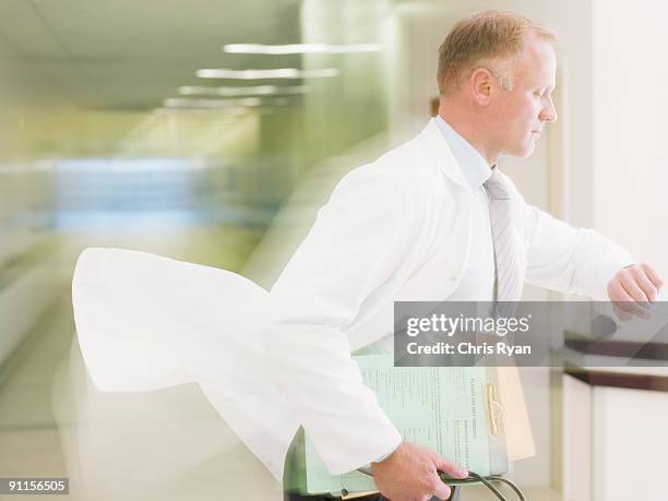 doctor rushing in hospital corridor - doctor authority stock pictures, royalty-free photos & images