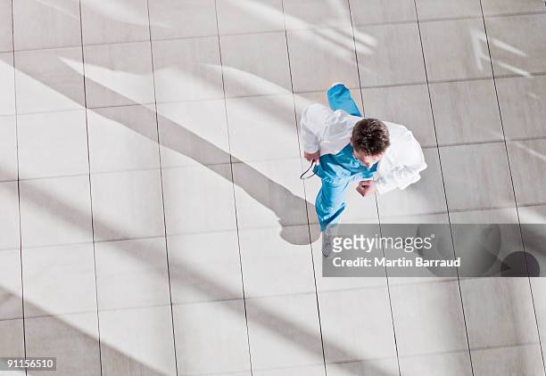 medico corre attraverso ospedale hall - overhead view foto e immagini stock