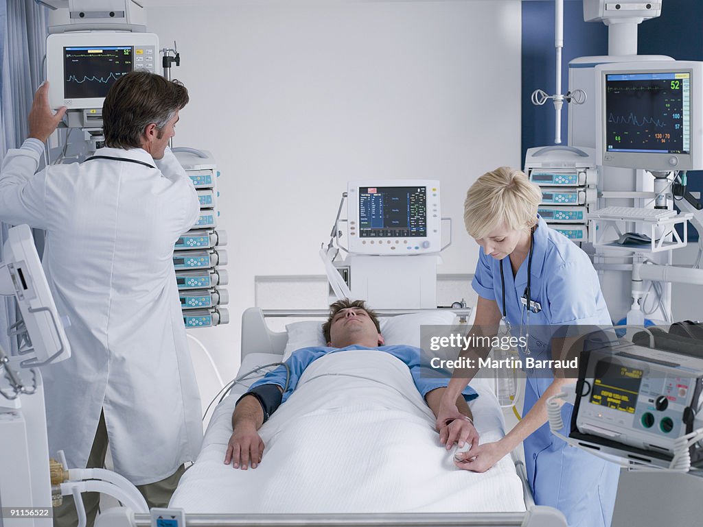 Doctor and nurse attending patient in intensive care