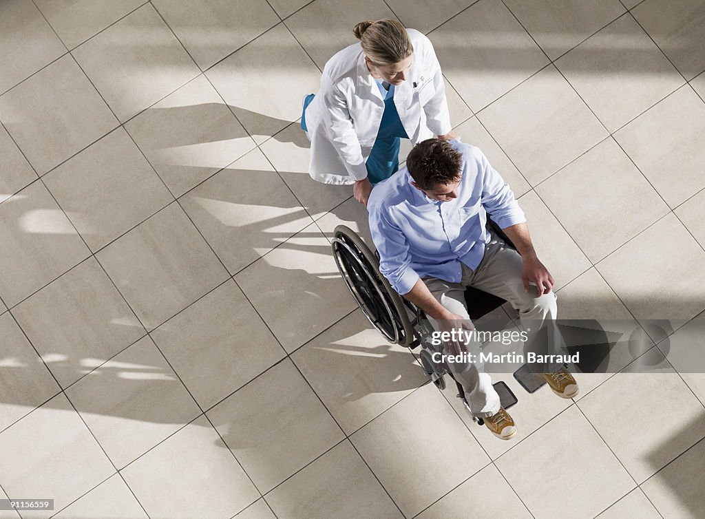 Doctor Mann im Rollstuhl Schieben