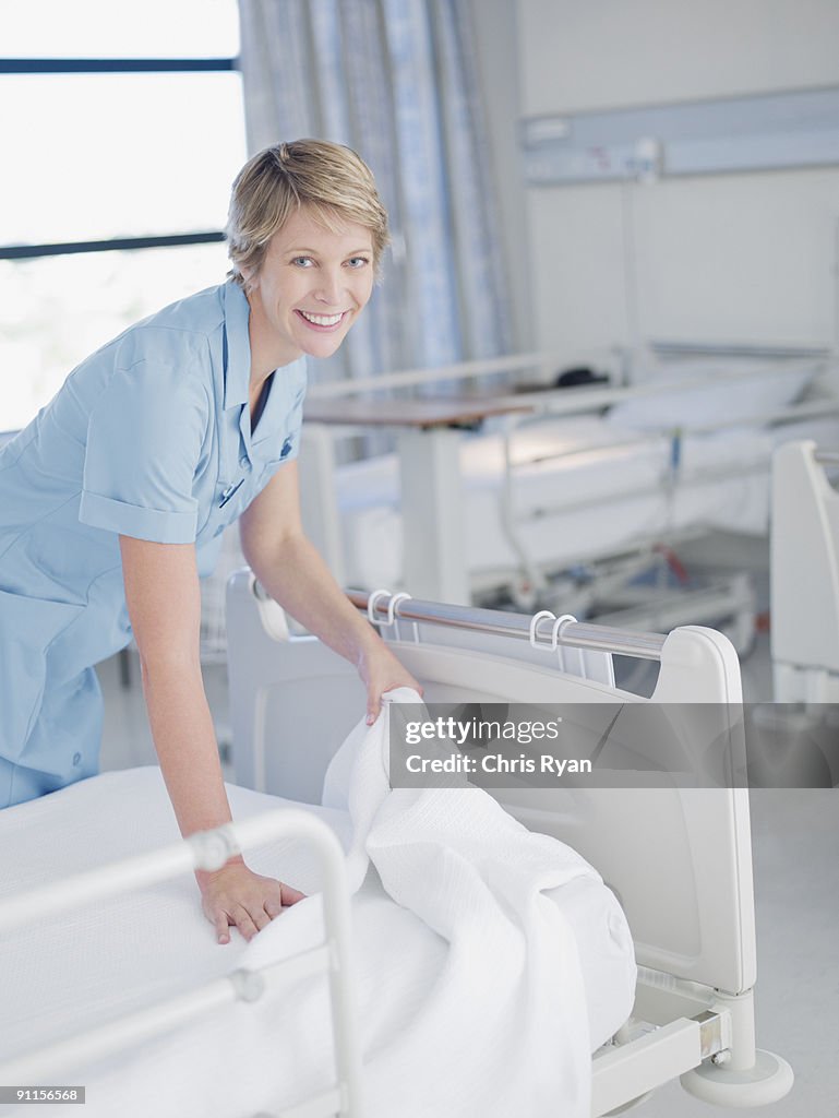 Nurse making up hospital bed