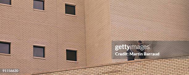 businessmen talking on balcony - low angle view of two businessmen standing face to face outdoors stock pictures, royalty-free photos & images