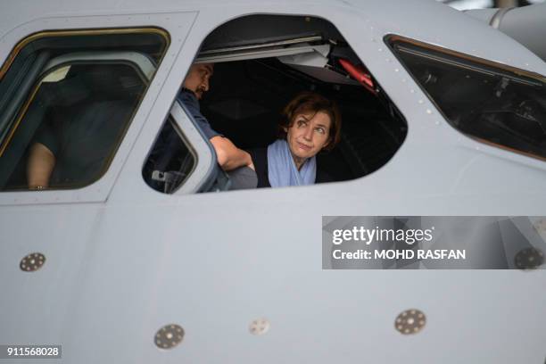 French Defence Minister Florence Parly looks out from the cockpit window of a Royal Malaysian Air Force Airbus A400M military transport plane during...