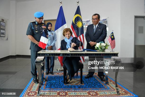 French Defence Minister Florence Parly signs a guest book during an official visit at the Subang Air Force base in Subang, outside Kuala Lumpur on...
