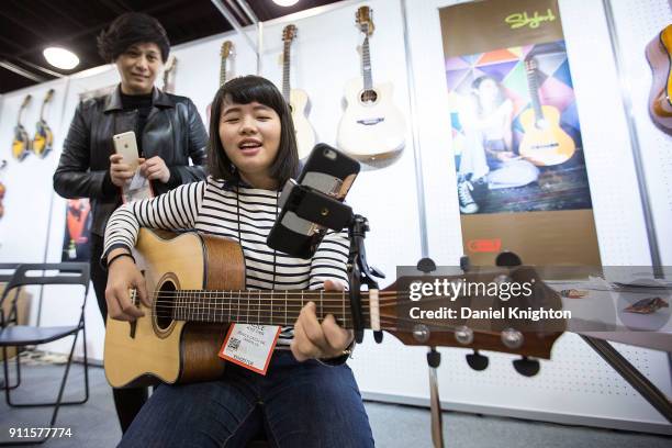 Musician Alice Chen demonstrates the Mobile Catch mobile phone holder at The 2018 NAMM Show at Anaheim Convention Center on January 28, 2018 in...