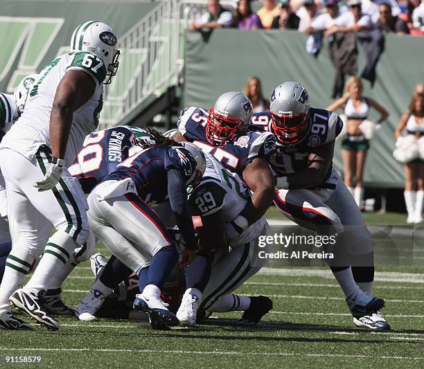 The Defense of the New England Patriots makes a gang tackle, led by Nose Tackle Vince Wilfork against the New York Jets at Giants Stadium on...