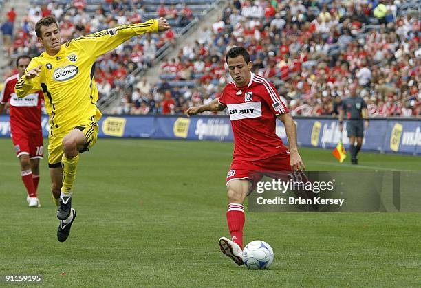 Marco Pappa of the Chicago Fire kicks the ball as Eric Brunner of the Columbus Crew defends during the first half at Toyota Park on September 20,...