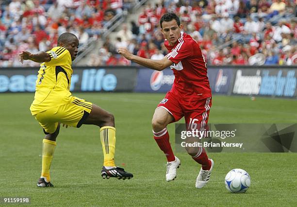 Marco Pappa of the Chicago Fire moves the ball up the field as Emmanuel Ekpo of the Columbus Crew defends during the first half at Toyota Park on...