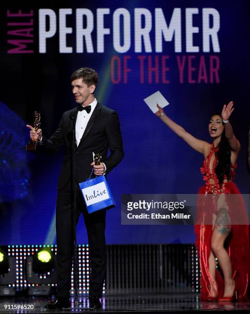 Adult film actor Markus Dupree accepts the award for Male Entertainer of the Year as presenter and adult film actress Gina Valentina cheers during...