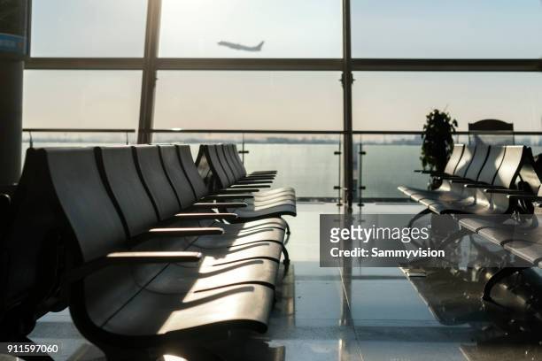 airport waiting area against airplane taking off - empty gate stock-fotos und bilder